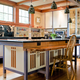 An example of an accessible kitchen designed by John Salmen. Note the wider corridors, a counter extension that can accommodate a wheelchair, and grab bars.